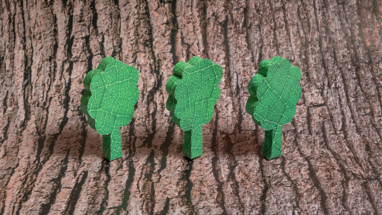 An image showing a trio of three-dimensional trees made out of an image of a leaf against a bark background.