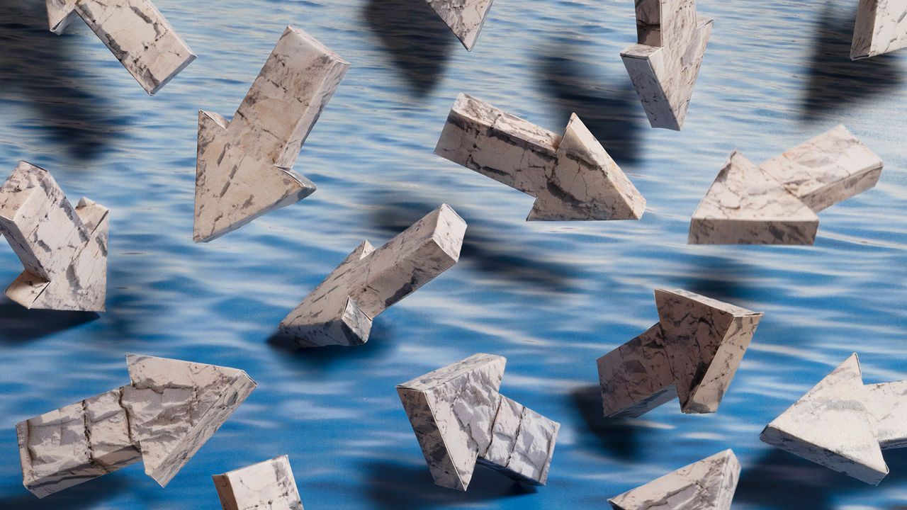 An image showing lots of three-dimensional arrows made out of limestone pointing in all directions against a calm water background.