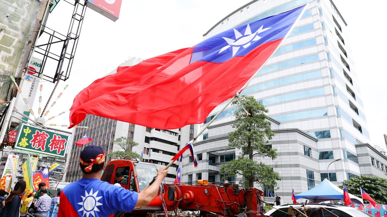 A supporter of the Kuomintang party waves a Taiwanese flag in Taipei, Taiwan